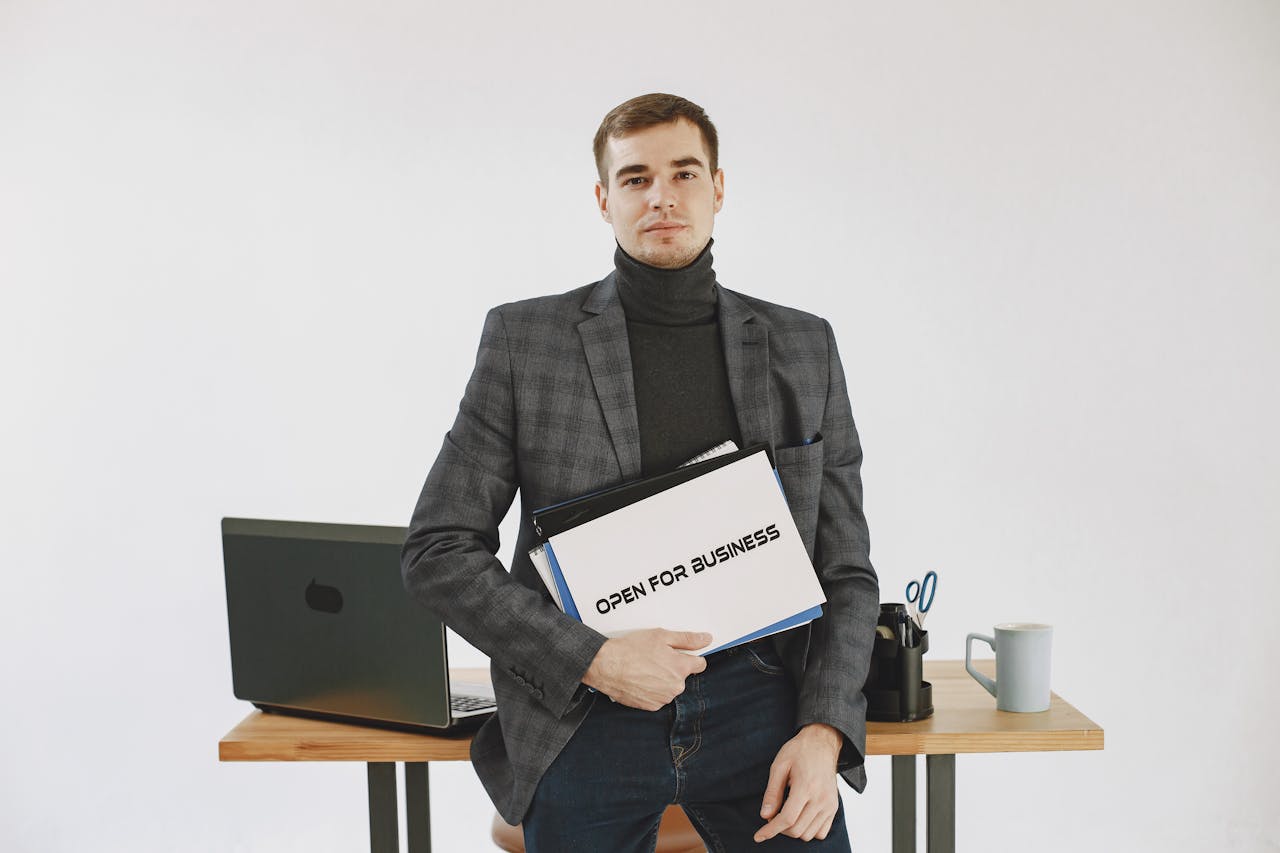 Businessman in corporate attire holding open for business sign, ready to work.